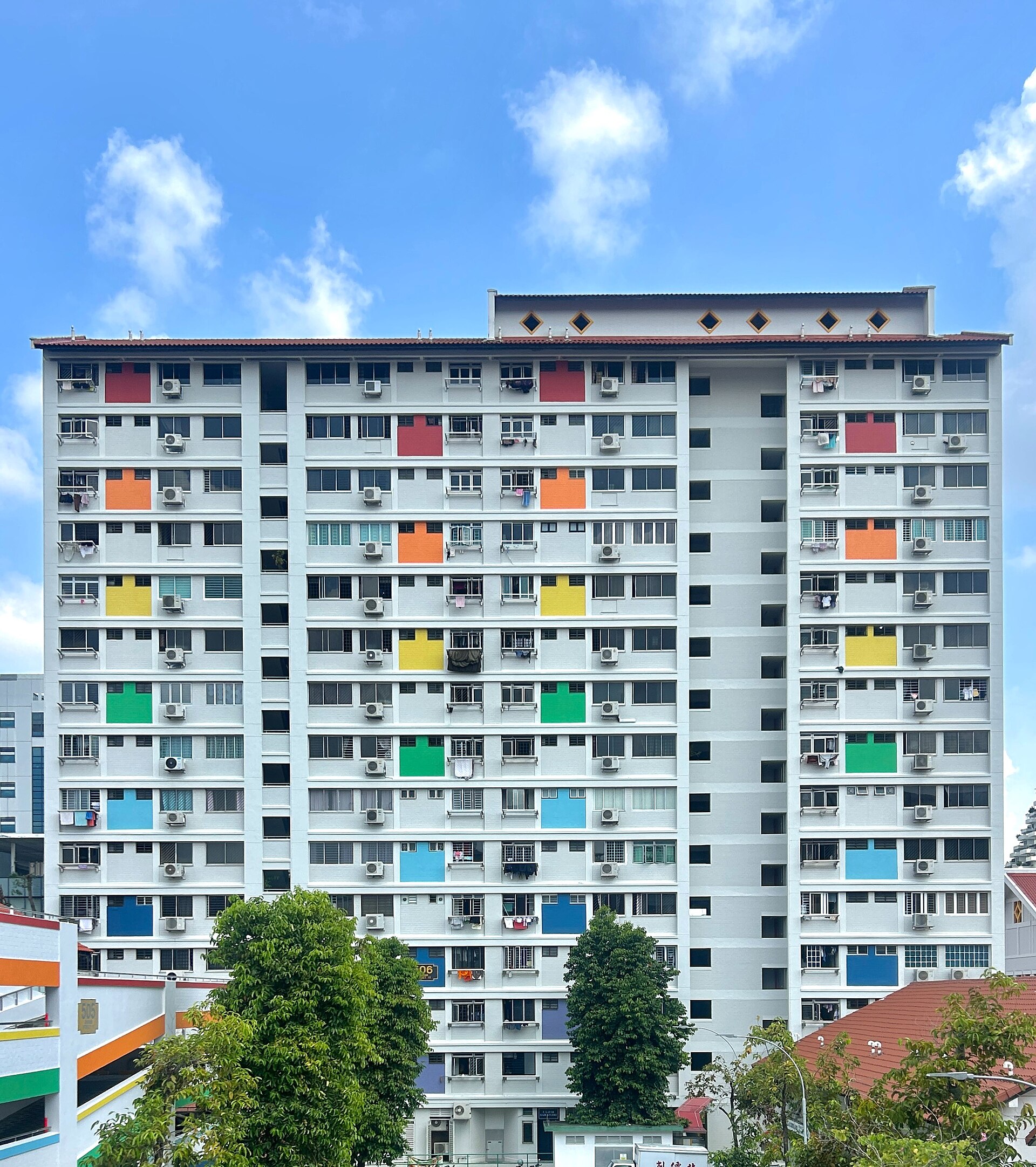 The facade of HDB apartment block 506 in Bishan, Singapore: a grid of shuttered windows, air-con units and painted balcony rails.