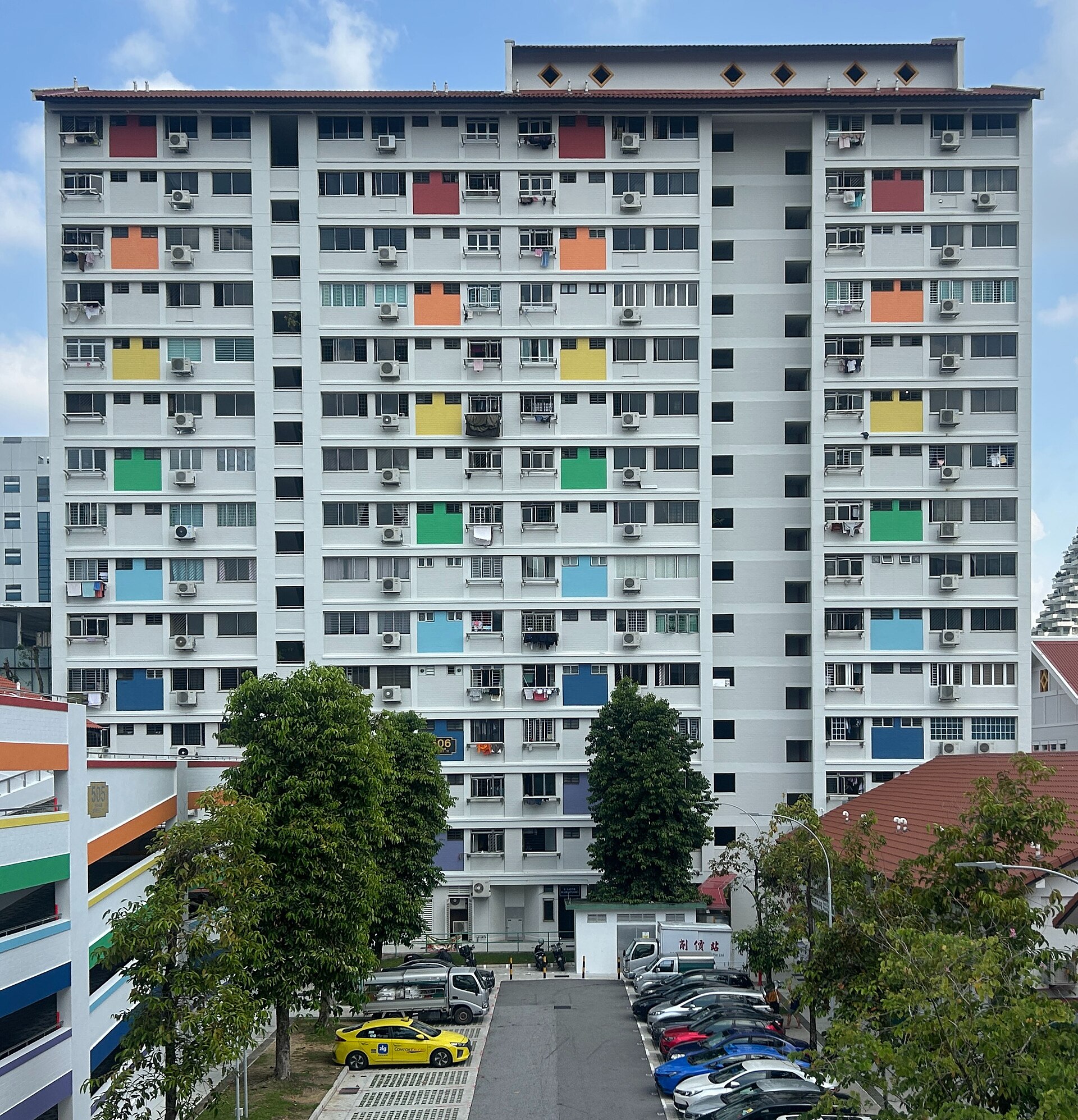The ground level of HDB block 506 in Bishan, showing multi-storey parking, the void deck and a painted wall.