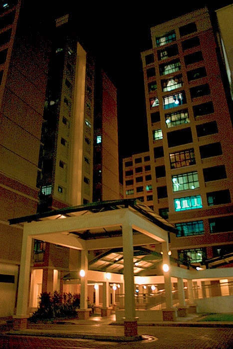 A pair of HDB flats in Woodlands seen from below, with the service yard and covered walkways in front.